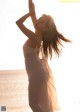 A woman in a white dress standing on the beach.