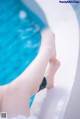 A woman's bare feet by a swimming pool.