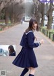 A woman in a school uniform is walking down the street.