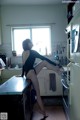 A woman in a black leotard sitting on a kitchen counter.