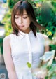 A woman in a white shirt is posing for a picture.