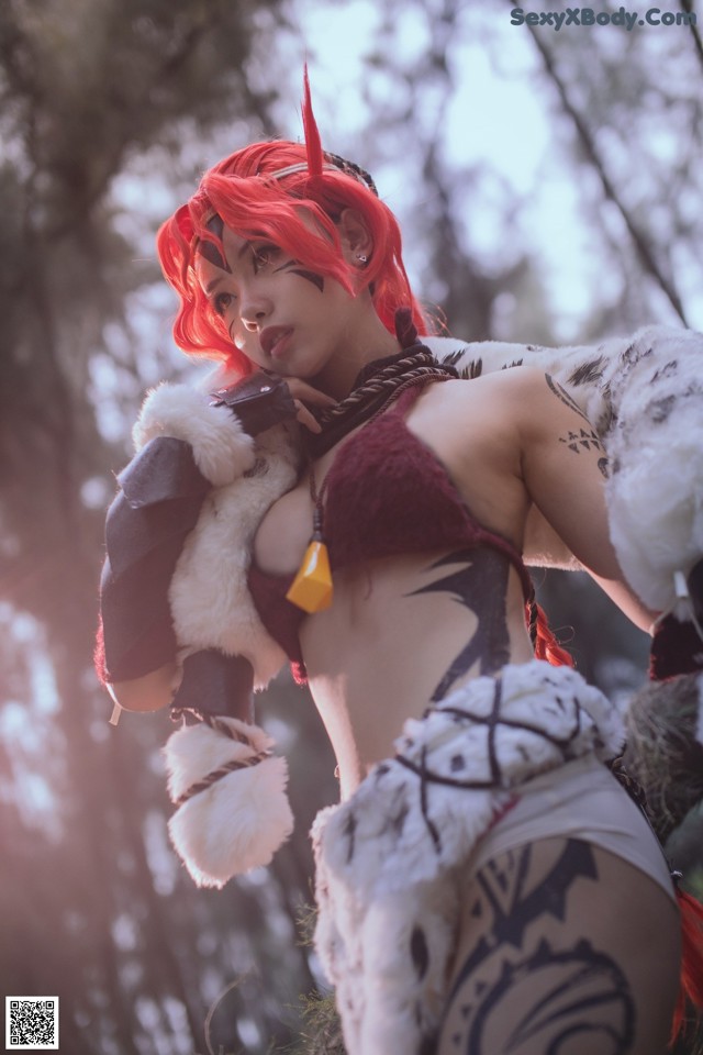 A woman with red hair is posing for a picture.