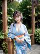 A woman in a blue kimono posing for a picture.